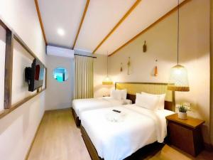 a hotel room with two beds and a tv at BARA BARA' Budget SATUN 'SHA Plus' in Satun