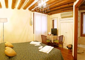 a bedroom with a bed and a dining room with a table at Hotel San Luca Venezia in Venice