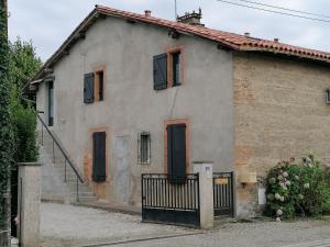 una vecchia casa con un cancello davanti di L'Oustal a Montech