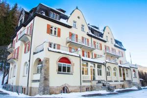 un gran edificio con nieve en el suelo en Gruppenhaus Lindenhof Churwalden en Churwalden