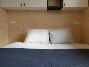 een slaapkamer met een bed met 2 kussens bij Het Huisje comfortabel, luxe & sfeervol nabij het strand in Biggekerke