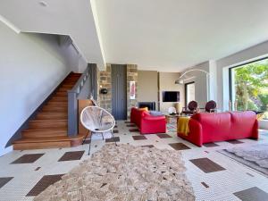 salon z czerwonymi meblami i schodami w obiekcie Superbe villa vue sur mer, corniche de la plage w mieście Bénodet