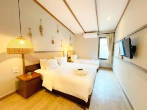 a hotel room with two beds and a tv at BARA BARA' Budget SATUN 'SHA Plus' in Satun