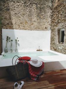 bañera en una habitación con pared de piedra en CAN TANDO Restored catalan old barn to enjoy peaceful rural simplicity, en Sant Jordi Desvalls