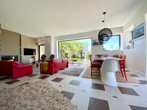 salon z czerwoną kanapą i stołem w obiekcie Superbe villa vue sur mer, corniche de la plage w mieście Bénodet