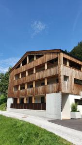 aartment building with a wood fasade and a sidewalk w obiekcie Apartments Zauberberg w mieście Hainzenberg