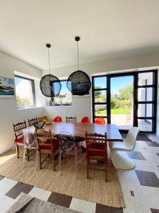 uma sala de jantar com uma mesa de madeira e cadeiras em Superbe villa vue sur mer, corniche de la plage em Bénodet