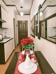 - une table à manger avec un vase de roses dans l'établissement Centropolis Queen Bed Suite- Modern Posh Style, à Manille