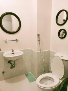 La salle de bains est pourvue de toilettes et d'un lavabo. dans l'établissement Centropolis Queen Bed Suite- Modern Posh Style, à Manille