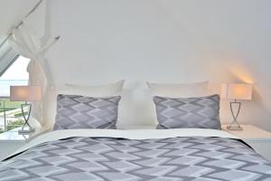 a bedroom with a bed with two lamps and a window at Haus Meeresrauschen Haus Meeresrauschen Appartement 1 6 in Haffkrug