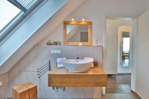 a bathroom with a white bowl sink on a wooden counter at Haus Meeresrauschen Haus Meeresrauschen Appartement 1 6 in Haffkrug +34 photos