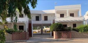 a white building with a gate in front of it at Gallipoli Mancaversa Futura Vacanza Andrea in Marina di Mancaversa