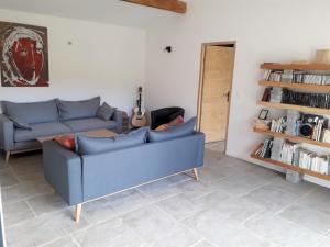 a living room with a blue couch and a guitar at Suite chez l'habitant in Itxassou