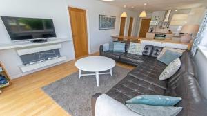 een woonkamer met een bank en een tafel bij Swallows Croyde - Open plan beach chalet & close proximity to the beach - Sleeps 6 in Croyde