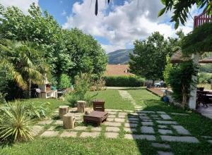 a garden with a bench and a table in the grass at Suite chez l'habitant in Itxassou