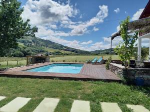 a swimming pool in a yard next to a house at Suite chez l'habitant in Itxassou