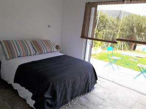 a bedroom with a bed and a large window at Suite chez l'habitant in Itxassou