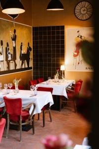 una sala da pranzo con tavoli bianchi e sedie rosse di Amadeus Restaurant & Boutique Hotel a Well