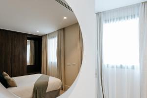 1 dormitorio con cama y espejo en Dock 1 Suites en Santa Cruz de Tenerife