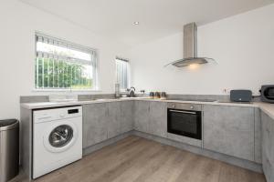 a kitchen with a washing machine and a sink at A cosy, modern 3 bedroom house in Middlesbrough in Middlesbrough