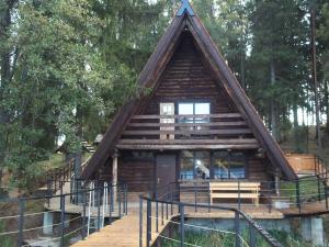 a log cabin in the woods with a staircase leading to it at Silmači in Launkalne