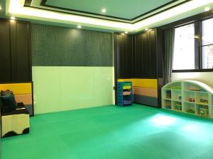 冠月精品旅館-Puli Ease Hotel في بولي: غرفة ذات أرضية خضراء وجدران صفراء وبيضاء
