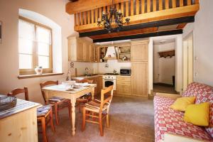 een keuken en een woonkamer met een tafel en stoelen bij La Marmote Albergo Diffuso di Paluzza Rio Bavous in Paluzza