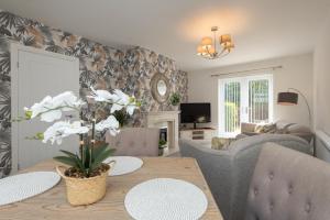a living room with a table and a couch at A cosy, modern 3 bedroom house in Middlesbrough in Middlesbrough