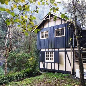 uma casa azul e branca na floresta em Walhalla Guesthouses em Walhalla