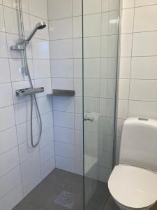 La salle de bains est pourvue d'une douche en verre et de toilettes. dans l'établissement Morlanda B&B, à Ellös