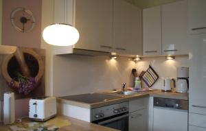 a kitchen with white cabinets and a sink and a stove at Haus Meeresblick - Ferienwohnung Meerblick (Ref. 128699) in Baabe