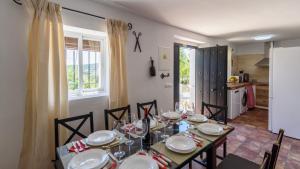 ein Esszimmer mit Tisch und Stühlen und eine Küche in der Unterkunft Casa La Limosna Setenil de las Bodegas by Ruralidays in Setenil de las Bodegas