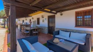 eine Außenterrasse mit blauen Möbeln und einem Tisch in der Unterkunft Cortijo Carmen de Vélez Vélez-Málaga by Ruralidays in Vélez-Málaga