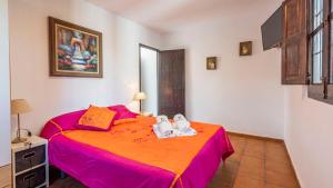 ein Schlafzimmer mit einem großen Bett mit einer rosa Tagesdecke in der Unterkunft Cortijo Carmen de Vélez Vélez-Málaga by Ruralidays in Vélez-Málaga + 23 Fotos