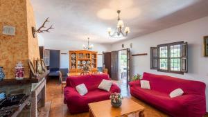 ein Wohnzimmer mit zwei roten Sofas und einem Kamin in der Unterkunft Cortijo Carmen de Vélez Vélez-Málaga by Ruralidays in Vélez-Málaga