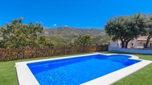 ein Pool in einem Garten mit einem Zaun in der Unterkunft Cortijo Carmen de Vélez Vélez-Málaga by Ruralidays in Vélez-Málaga