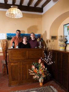 un grupo de tres personas parados detrás de un mostrador en Agriturismo La Topaia, en Borgo San Lorenzo