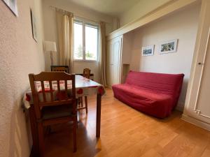 - un salon avec un canapé rouge et une table dans l'établissement La Residence - n° 05 - T2 classé **, à Gréoux-les-Bains
