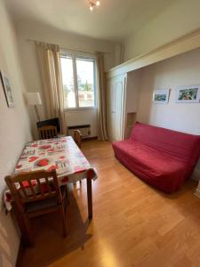 - un salon avec un lit rouge et une table dans l'établissement La Residence - n° 05 - T2 classé **, à Gréoux-les-Bains