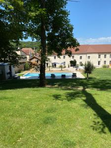 a tree in a yard with a swimming pool at Le Domaine Des Sources in Saint-Martin-dʼAblois