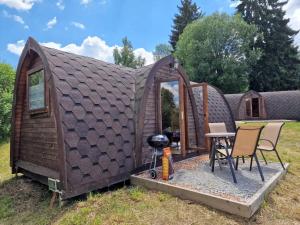 a tiny house with a grill in the yard at Hobití chatka Lipno in Černá v Pošumaví