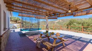 a patio with a picnic table and a swing at Villa Cinco Soles Árchez by Ruralidays in Árchez