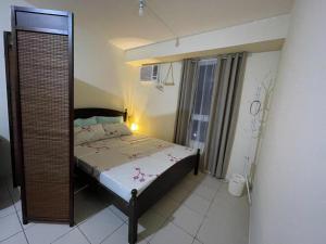 małą sypialnię z łóżkiem i lustrem w obiekcie Urban Deca Homes Manila Rustic Cozy Staycation w mieście Manila