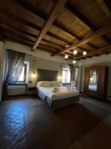 Un dormitorio con una cama grande en una habitación con techos de madera. en Al Palazzetto, en Tívoli