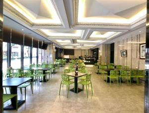 un comedor con mesas y sillas verdes en 冠月精品旅館-Puli Ease Hotel, en Puli