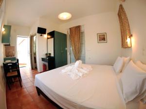 - une chambre avec un lit blanc dans l'établissement Tersanas Beach Lodges, à Tersanas