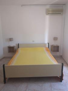 ein großes Bett in einem Zimmer mit 2 Tischen in der Unterkunft Torre d'Oriente in Rodi Garganico