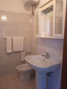 un bagno bianco con lavandino e WC di Torre d'Oriente a Rodi Garganico