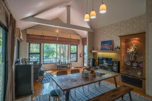 a living room with a table and a dining room at Villa Pitak Private Pool Villa Khaoyai in Ban Khanong Phra Nua