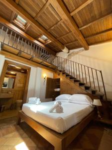 a bedroom with a large bed with a wooden ceiling at Al Palazzetto in Tivoli